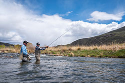 fly fishing guide advises angler, while both wading in the Weber River